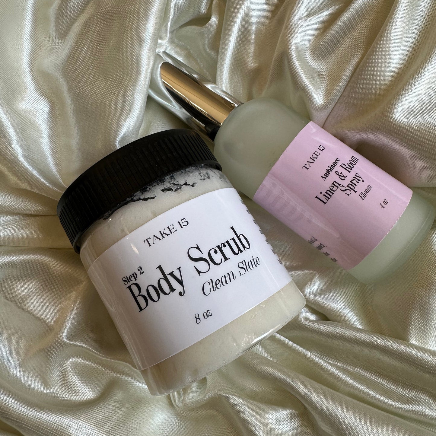 Two skincare products on a satin surface